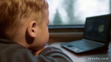 特写侧视图的小男孩看电影或<strong>卡通笔</strong>记本电脑，而旅行的火车上的焦点